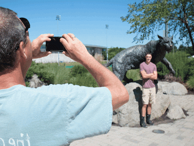 家长在野猫雕像前给孩子拍照