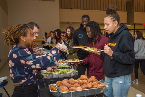 Students taking food at the Latinx Dinner