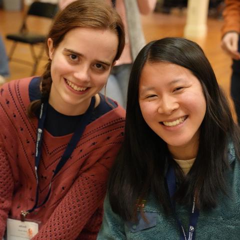 Two students sitting together and smiling at the camera.