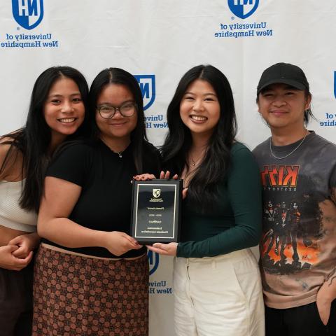 Four Students holding award plaque posing.