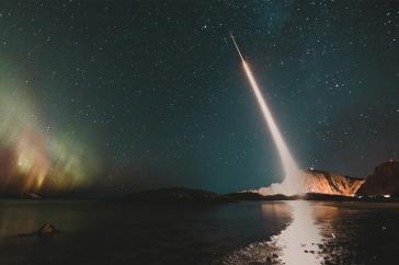 Rocket launches into the green Northern Lights.