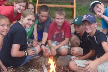 Campers gathered around a camp fire